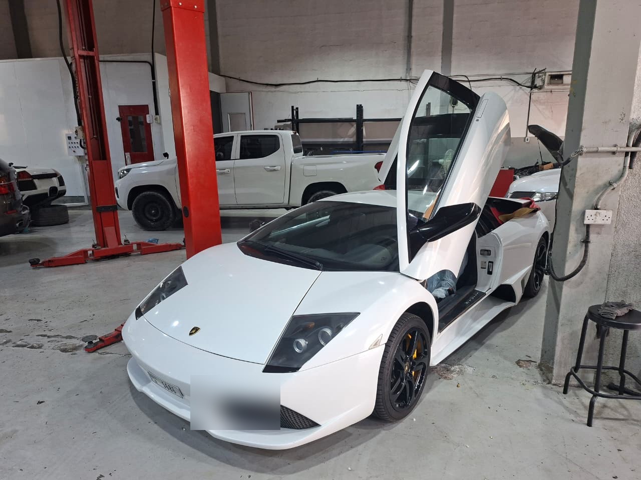 White Lamborghini with doors open for inspection